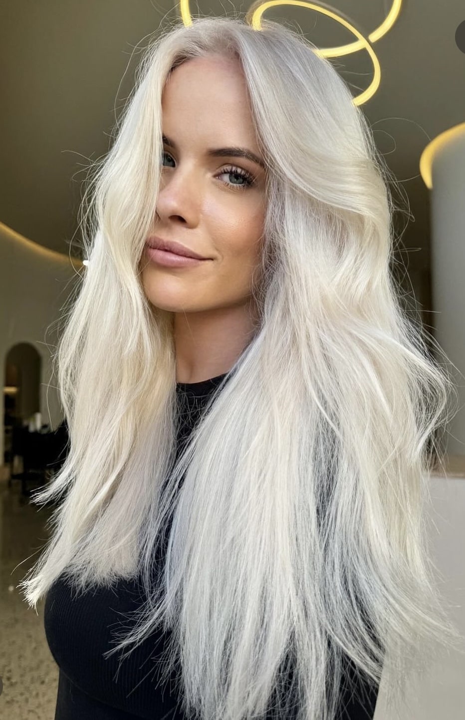 Wavy long blonde hair styled to the side, featuring the Platinum Blonde Service by blonde hairdresser in Melbourne.